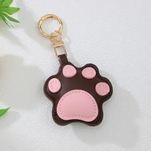 Detail view of a cute brown and pink leather cat paw keychain with golden hardware