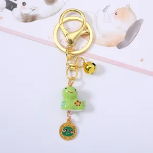 Detail view of cute green ceramic snake zodiac charm with golden bell on a keychain