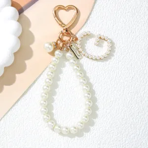 Detailed view of a pearl letter G and heart-shaped clasp on a Korean style keychain
