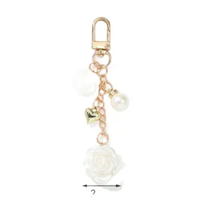 Eleganter goldfarbener Schlüsselanhänger mit weißen Rosen Perlen und einem Herzanhänger