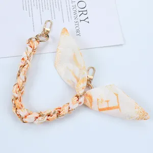 Detail of short phone strap chain with interwoven orange letter print silk scarf