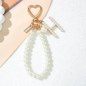Elegant pearl initial H keychain with gold heart clasp and wrist strap detail