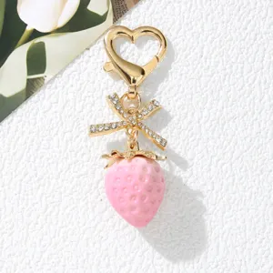 Close-up of a sweet pink strawberry keychain with a rhinestone bow and heart clasp