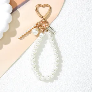 Macro detail view of elegant pearl keychain featuring heart buckle and gold accents