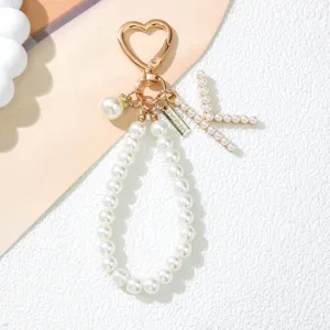 Close-up view of an elegant pearl letter K keychain with heart-shaped golden metal clasp.