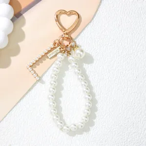 Close-up of elegant pearl letter L keychain with gold heart-shaped clasp and pearl charm
