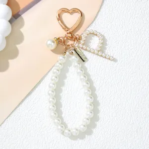 Close-up of pearl alphabet keychain with gold heart clasp and pearl letter P detail