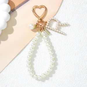 Detailed close-up of a pearl letter A keychain charm featuring a rose gold heart-shaped clasp.