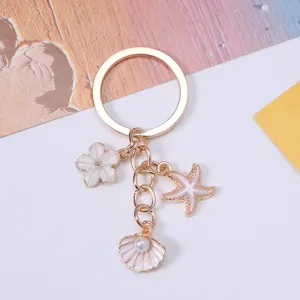 Close-up detail of ocean-themed alloy keychain with starfish, seashell, and pearl