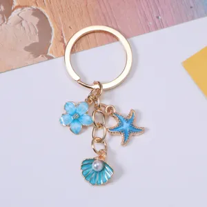 Detailed view of ocean-themed keychain with blue starfish and pearl shell charms