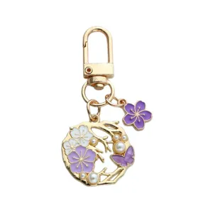 Elegant gold keychain with pearl floral wreath and purple sakura blossom charms