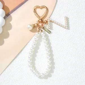 Detail of pearl letter J keychain with gold heart clasp and handmade tag