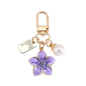 Elegante portachiavi a fiore di ciliegio in smalto viola con perla e targhetta d'oro