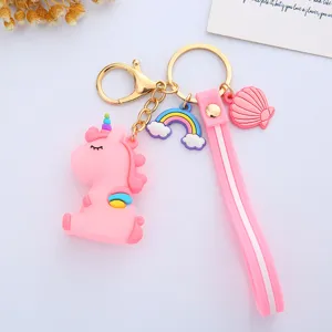 Close-up detail of a cute pink unicorn keychain featuring rainbow and shell charms and a pink strap