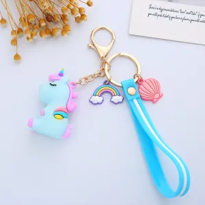 Close-up of a cute blue unicorn keychain with rainbow charm and soft blue silicone strap.