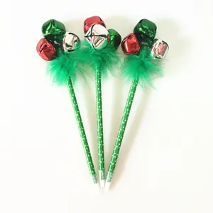 Détail de stylos de Noël avec clochettes colorées et plumes vertes festives