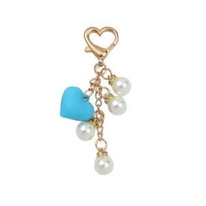 Porte-clés cœur doré élégant avec charme en silicone bleu et accents de perles sur blanc