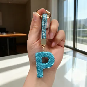 Detailed view of a turquoise rhinestone letter P keychain with gold-toned hardware