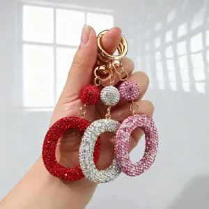 Gros plan de porte-clés lettre O sertis de strass en rouge, argent et rose brillant.