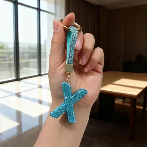 Detailed view of a sparkling blue rhinestone letter X keychain for bags and keys.