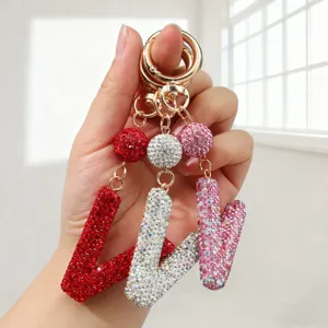 Vue détaillée de porte-clés lettre V incrustés de cristaux en rouge, blanc et rose brillant
