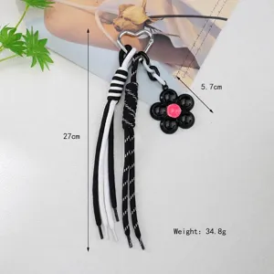 Detailed view of the heart-shaped ring keychain featuring a flower pendant and woven rope