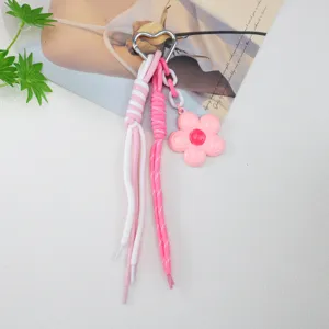 Close-up of pink flower keychain with braided rope and heart-shaped alloy ring.