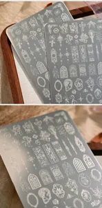 Macro view of Gothic style nail stamping plates with intricate rose and angel etchings