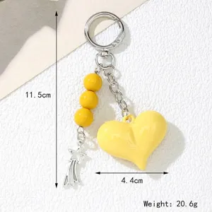 Detailed close-up view of a yellow acrylic heart keychain with size and weight markings
