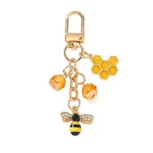 Exquisite gold-toned metal keychain featuring enamel bee, honeycomb charms and orange beads