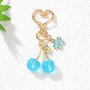 Detailansicht eines blauen Kirsch-Schlüsselanhängers mit herzförmigem goldener Verschluss.