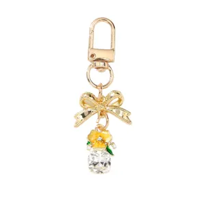 Porte-clés fleur dorée élégant avec nœud chic et grand pendentif en cristal carré