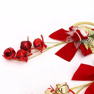 Primo piano di decorazione natalizia con campanelle, fiocchi rossi e Babbo Natale