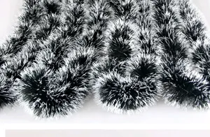 Close-up detail of dark green Christmas tinsel garland with white tips for tree decor
