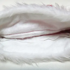 Close-up detail of thickened white plush lining for a red velvet Santa Christmas hat