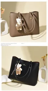 Detailansicht retro Pendler-Tragetaschen in Khaki und Schwarz mit Bärenanhänger.