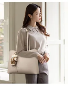 Elegante beige Tragetasche mit großer Kapazität, getragen von einem Modell in Innenräumen