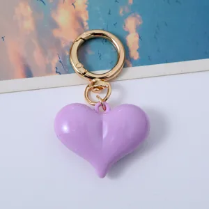 Detailed view of a shiny purple heart-shaped acrylic keychain with gold clasp.