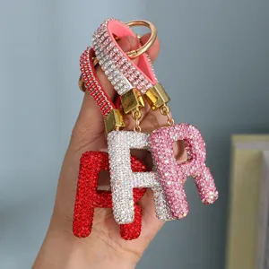 Close-up of sparkling rhinestone-encrusted letter A keychains in red, silver, and pink variants