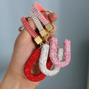 Detailed close-up of luxury sparkling rhinestone letter U keychains in red, white and vivid pink