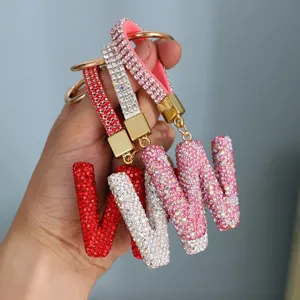 Hand-held view of sparkling rhinestone-encrusted 'W' initial keychains in multiple colors