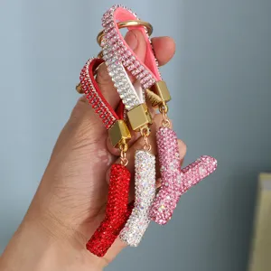 Close-up detail of luxury rhinestone initial letter keychains in red, white and pink