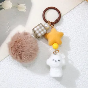 Detailed view of cute flocked white dog and brown pom-pom keychain with star bead