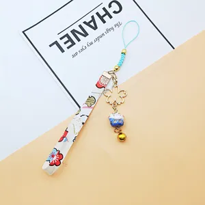 Japanese Maneki-neko lucky cat phone strap with golden Sakura charm and bell accessory