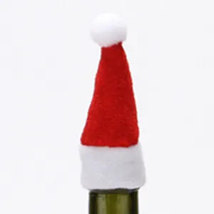 Red and white velvet Santa hat wine bottle cover for festive Christmas table decorations