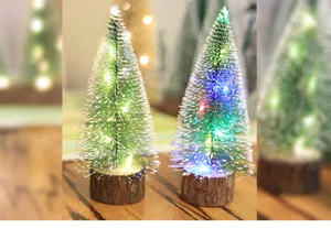 Primer plano de mini árboles de Navidad escarchados con luces LED de colores cálidos