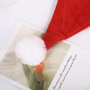Détail en gros plan d'un bonnet de Père Noël en feutre rouge avec un pompon blanc doux
