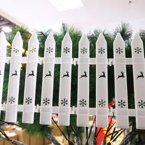 Close-up detail of white PVC Christmas tree fence featuring reindeer and snowflake cutouts