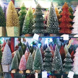 Detailansicht bunter Mini-Zeder-Weihnachtsbäume mit einem dekorativem Schneeeffekt