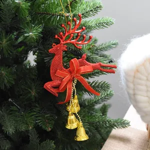 Detailed view of a red reindeer Christmas ornament with golden bells on a tree.